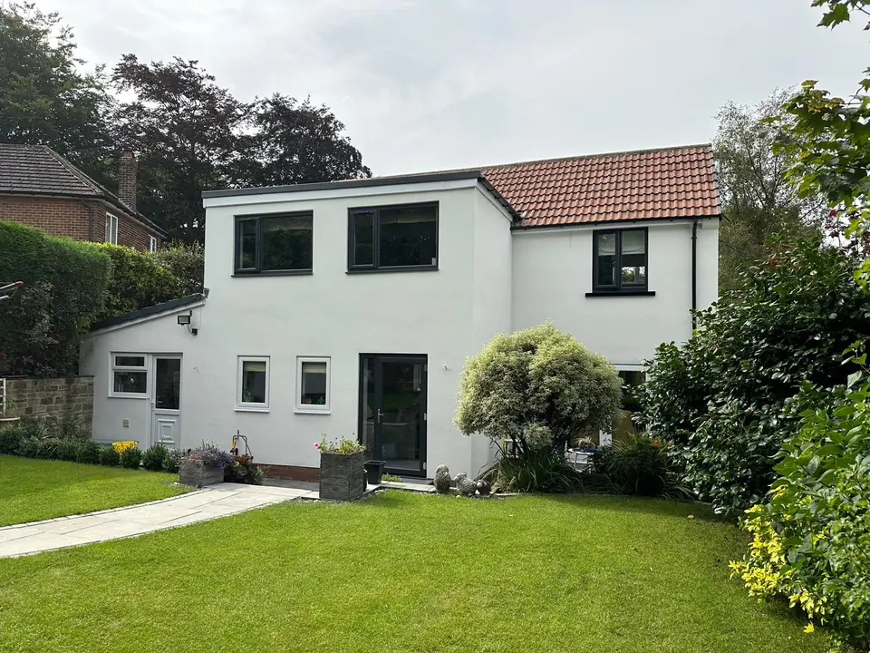 The same detached house finished in a smooth white render with dark window frames