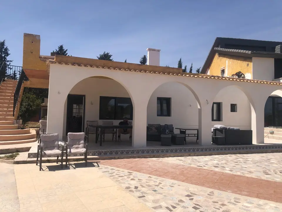 Spanish villa with rendered arches, finished in natural tones