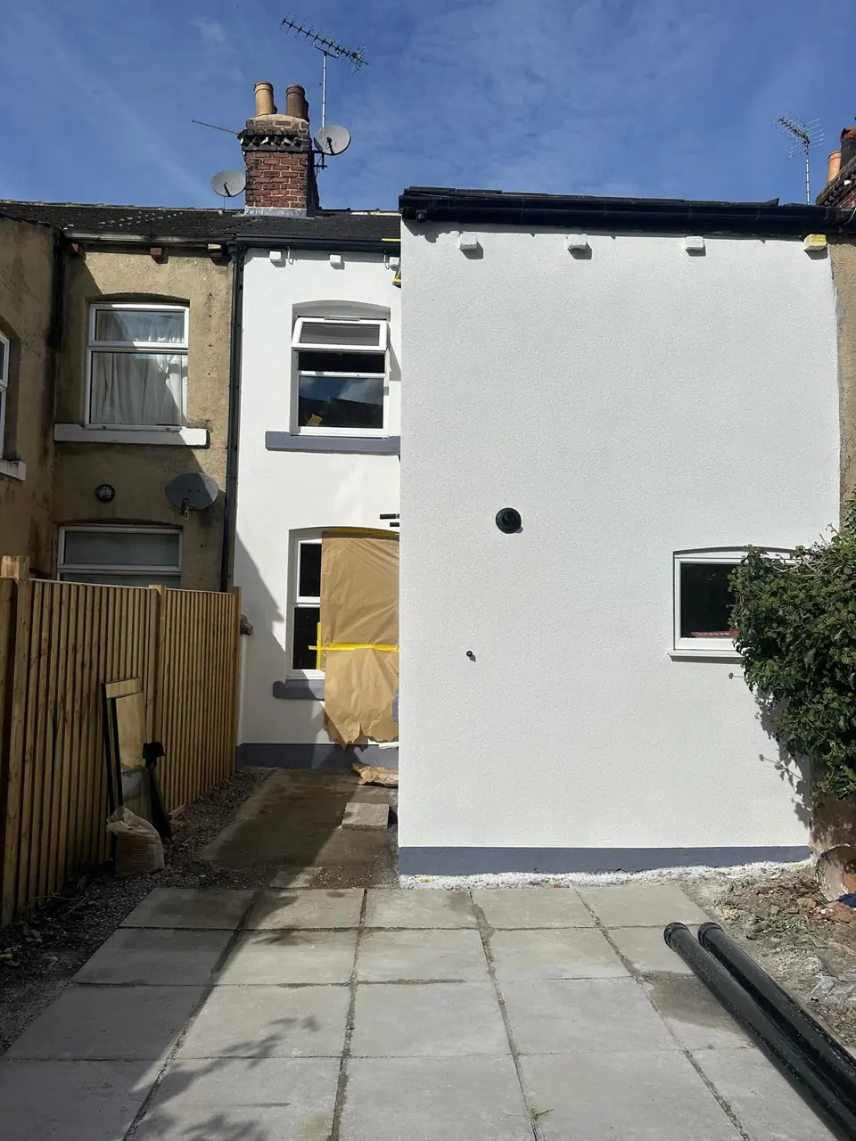 The same rear terrace wall after rendering, clean and white